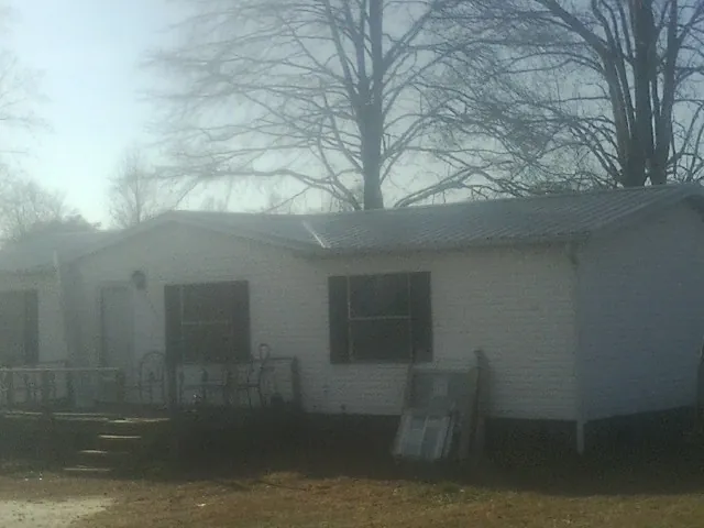 New metal roof on a white painted brick home on a foggy morning in Sheldon